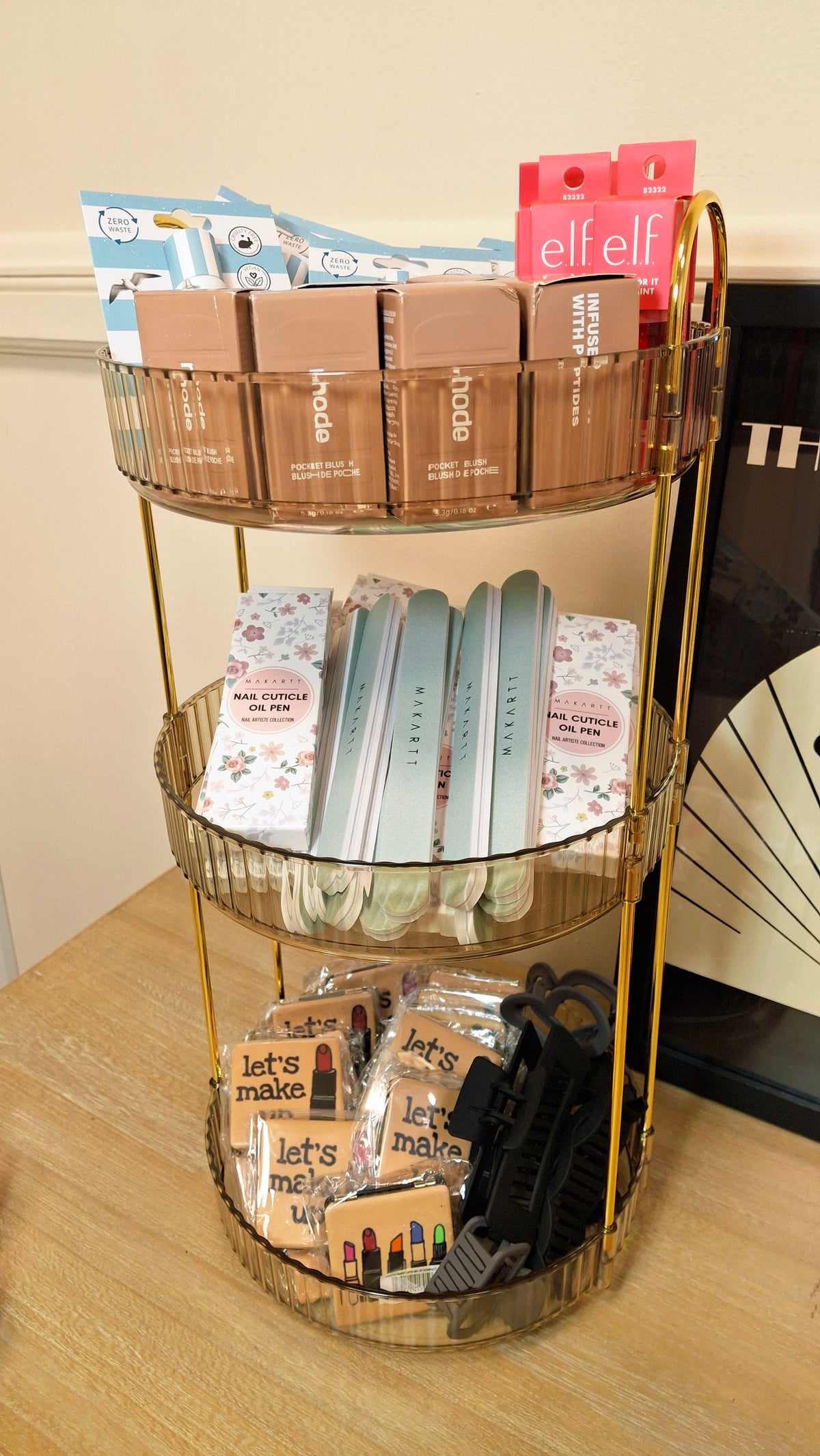 A storage rack filled with beauty products, hair clips and compact mirrors.