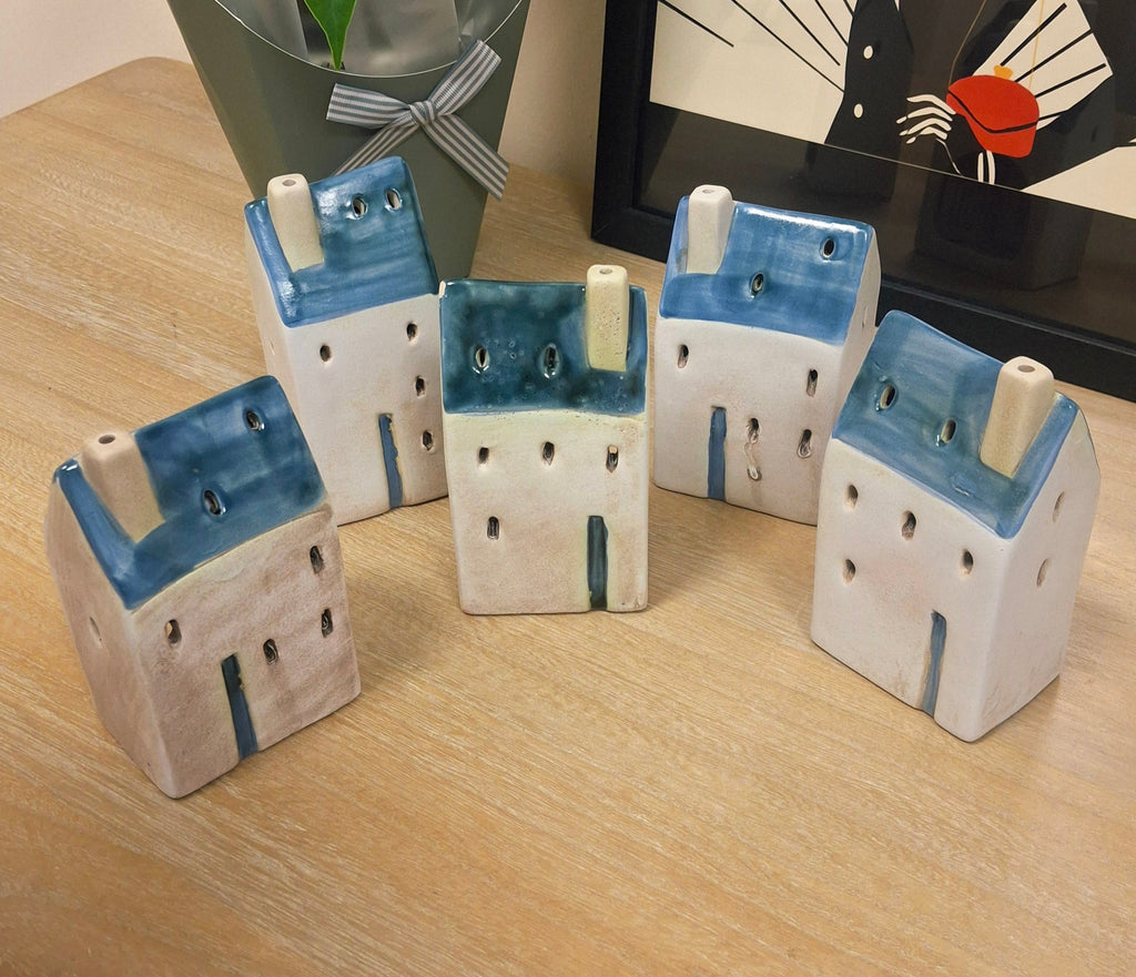 Five decorative coastal house tealight holders. 