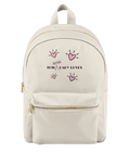 An off-white nylon backpack with gold zippers and a front pocket, featuring a pink and black graphic print that reads 'This Little Lady Loves' with heart illustrations.