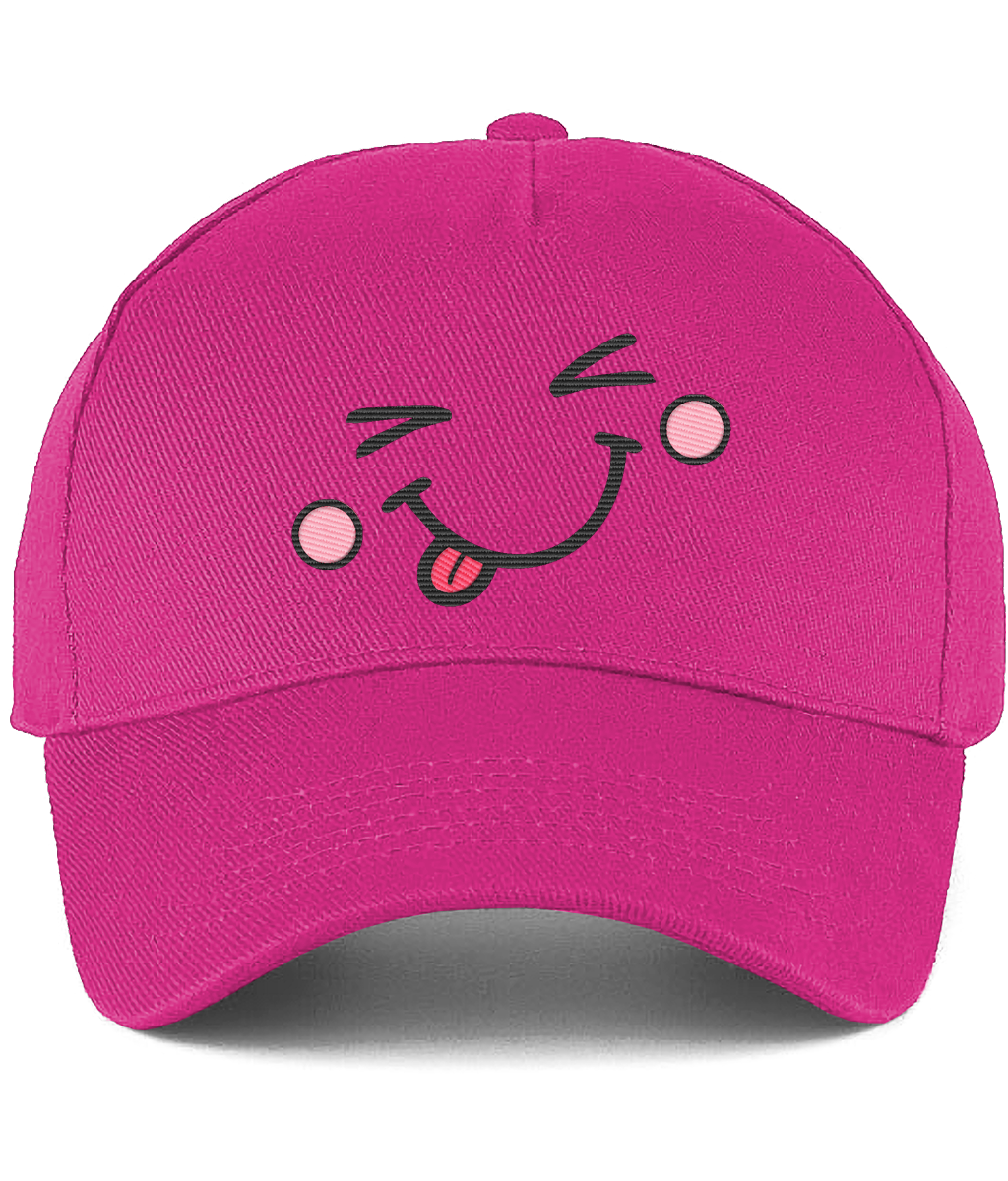 A bright pink baseball cap featuring a cartoon face embroidery on the front with winking eyes, pink cheeks, and a sticking-out tongue.