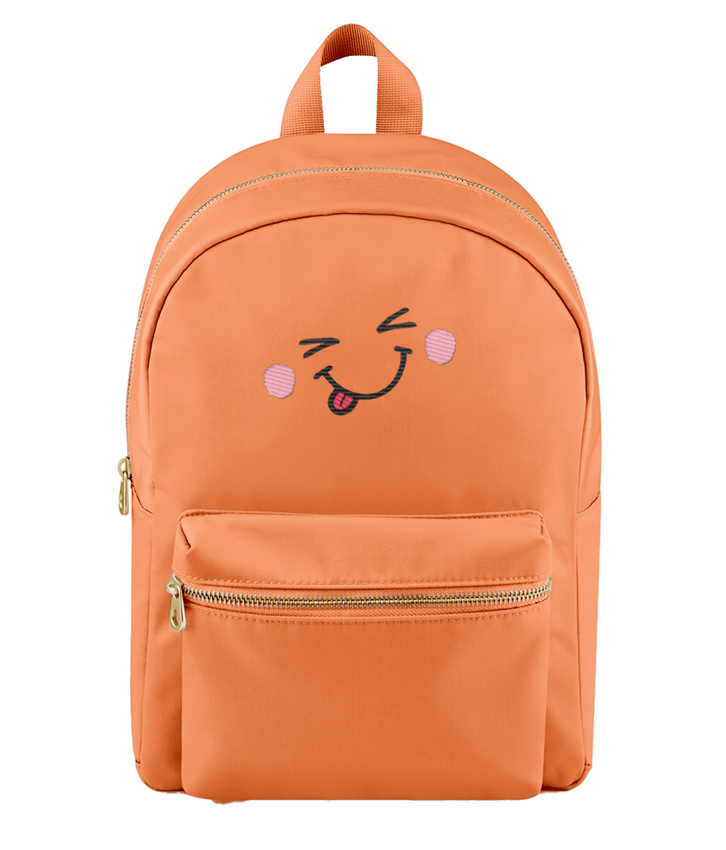 An orange nylon backpack with a gold zipper, featuring an embroidered winking face with pink cheeks and a sticking-out tongue on the front pocket.