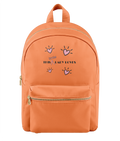 An orange backpack with a front zippered pocket and top handle, featuring a graphic print of pink hearts and the text 'this little lady loves' in black and pink on the front.