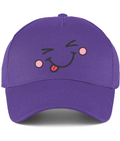 A purple baseball cap featuring a playful embroidered face on the front with winking eyes, pink cheeks, and a sticking-out tongue.