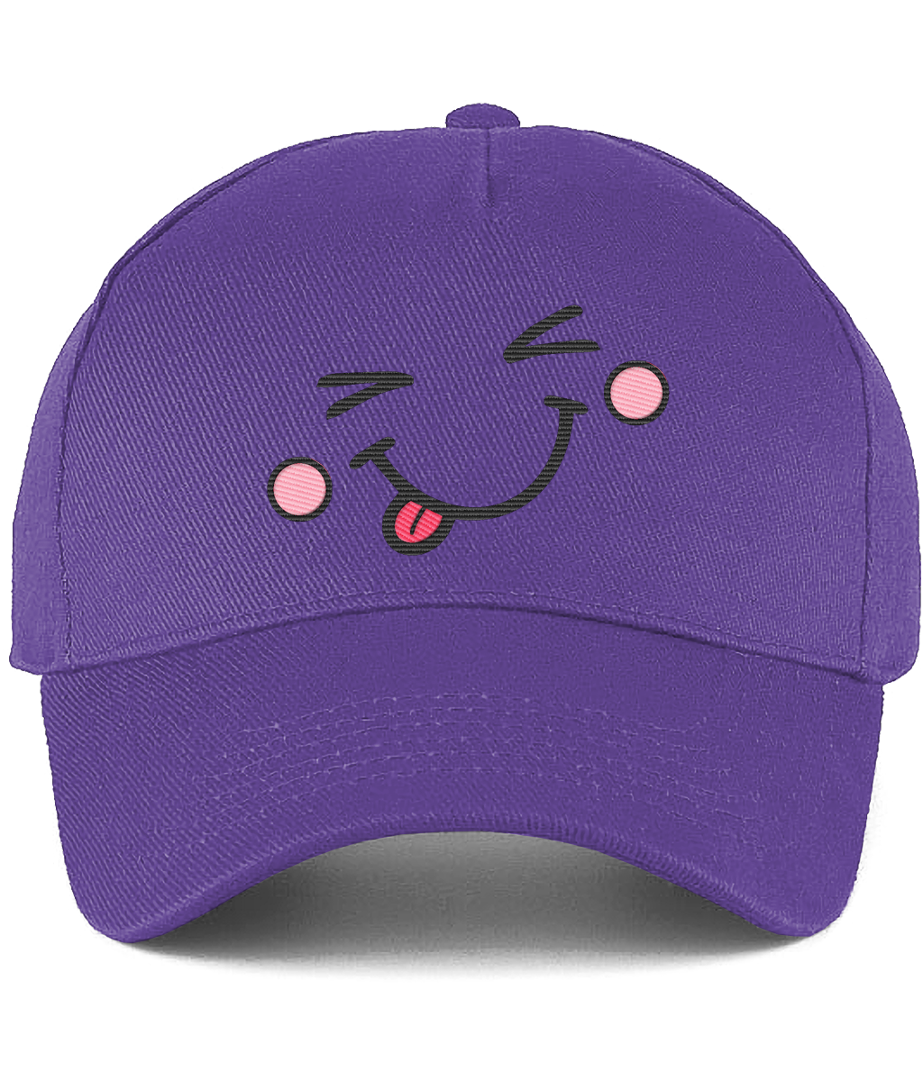 A purple baseball cap featuring a playful embroidered face on the front with winking eyes, pink cheeks, and a sticking-out tongue.